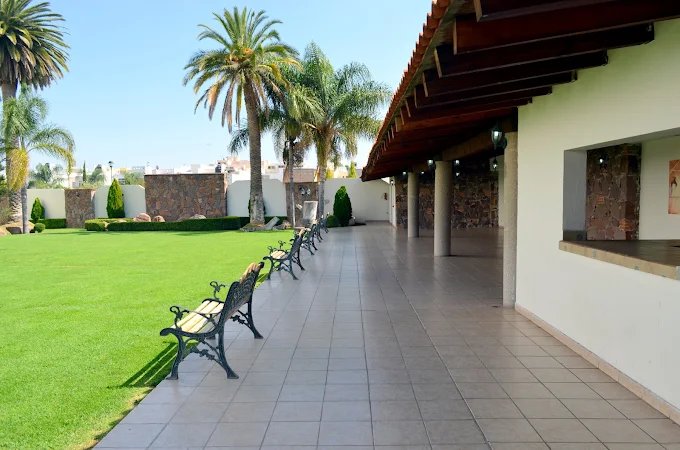 Jardín de El Campanario con corredor, pasto y palmeras